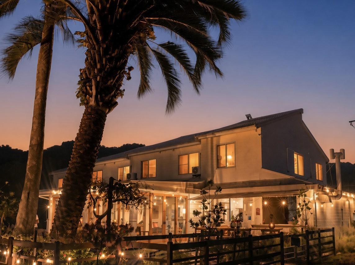 The beach house at dusk, palms and string lights